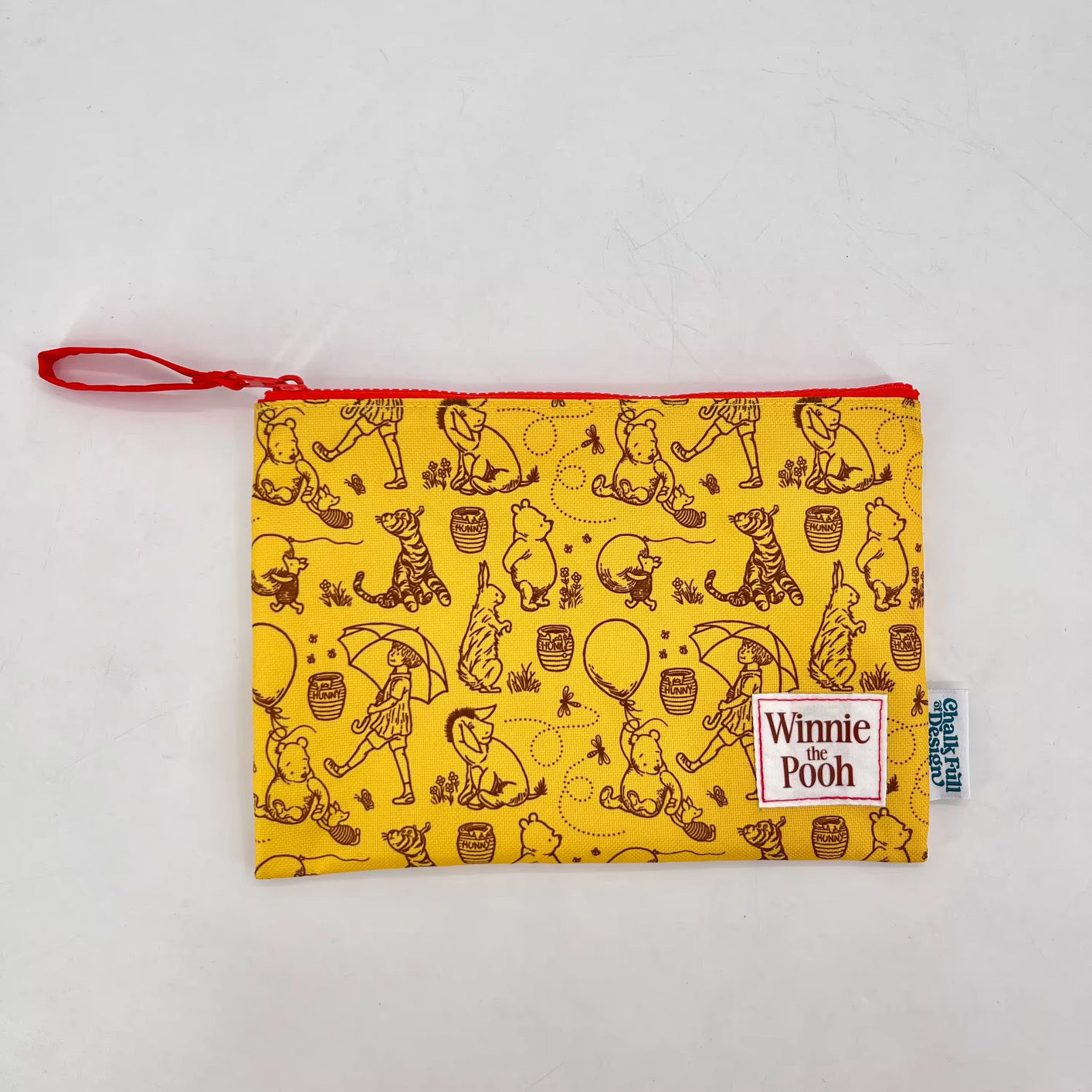 Yellow pouch with Winnie the Pooh pattern on a white background