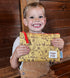 Child holding a Winnie the Pooh pouch against a wooden background